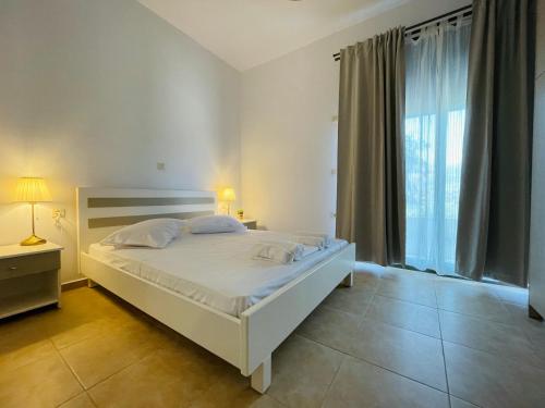 阿尔戈斯托利翁Michael's House - Argostoli的卧室设有白色的床和大窗户