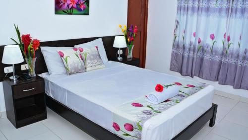 塔拉波托Residencial Lago Verde的一间卧室,床上放着鲜花