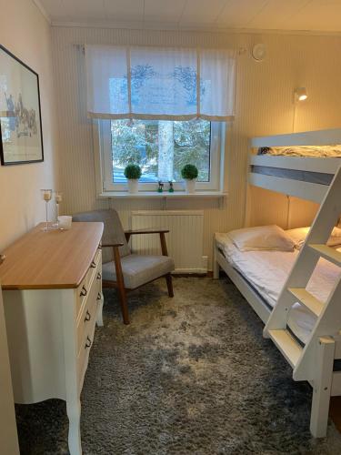 SlagnäsModern Lapland Cottage with Outdoor Sauna & BBQ Hut的一间卧室配有双层床和书桌