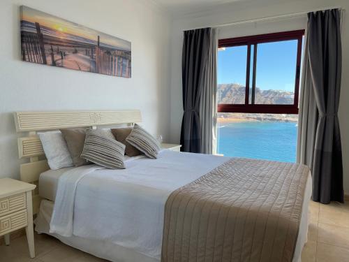 库拉海滩Su Eminencia - Luxury Apartment的一间卧室设有一张大床和一个大窗户