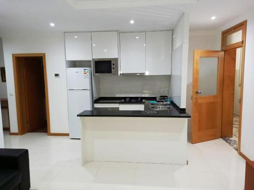 普拉亚Apto Morabeza T2 Praia的厨房配有白色橱柜和黑色台面