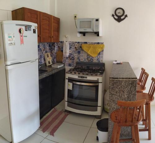卡博迪圣阿戈斯蒂尼奥Reserva dos Corais的厨房配有白色冰箱和炉灶。