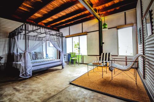 Mandaran NewaraTea and Experience Factory - Thema Collection的一间卧室配有天蓬床和桌椅