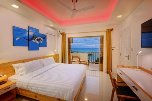 弗里德胡Luau Beach Inn, Maldives的一间卧室设有一张床和一个海景阳台