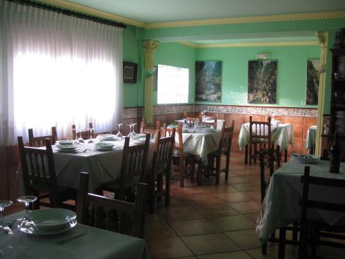 TielveHostal el Duje的用餐室设有桌椅和绿色的墙壁