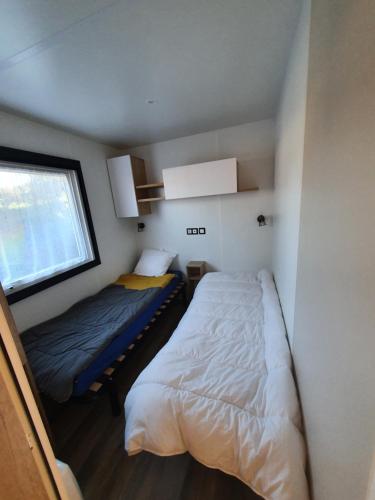 莱马特Mobil Home 2022 les charmettes 3 Chambres 40m2的一间小卧室,配有两张床和窗户