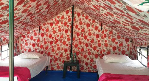 瑞诗凯诗The Raajas - Camp & Resorts的一间设有两张床和红色墙壁的客房