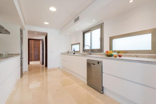 克里斯托港Villa Es Falcons的一间设有白色墙壁和不锈钢用具的大厨房