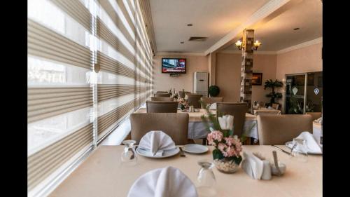 阿达纳kristal otel adana的一间带桌椅和电视的用餐室