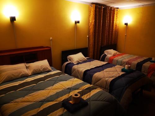 阿亚库乔Hostel Las Gardenias Ayacucho的一间酒店客房,房间内设有三张床