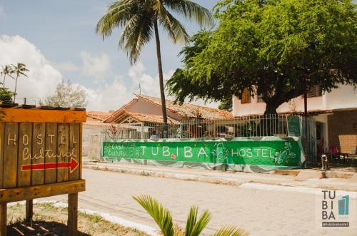 塔曼达雷Tubiba Hostel的一条有绿色围栏和棕榈树的街道
