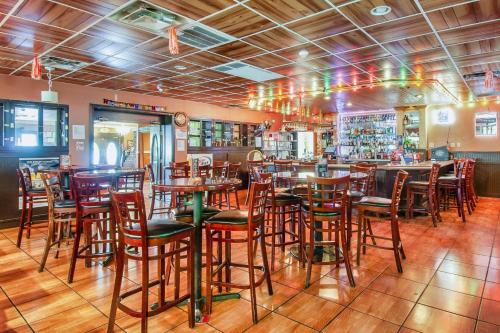 约翰逊城Days Inn & Suites by Wyndham Johnson City的一间带木桌椅的餐厅和一间酒吧