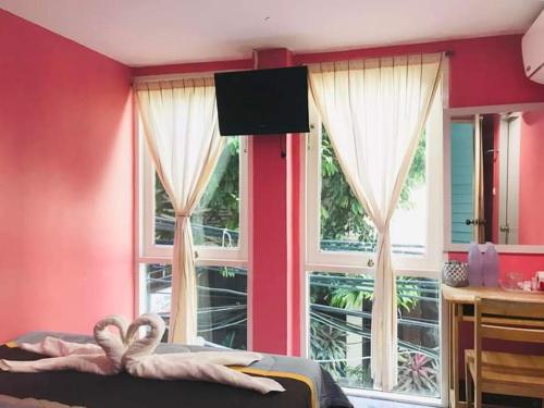 皮皮岛Sea Shell Hut的卧室设有粉红色的墙壁、窗户和一张床