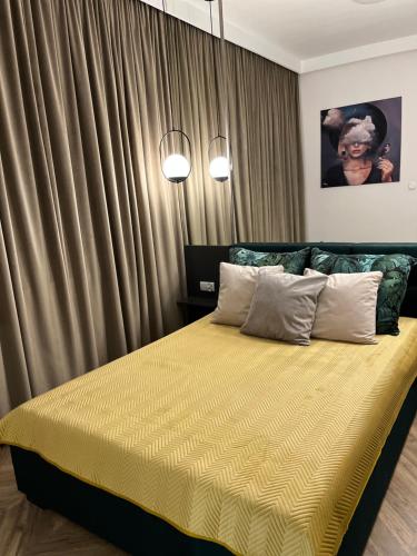 布罗德尼察Apartament Sweet Dream Longinówka的一间卧室配有一张带黄色床单和窗帘的床