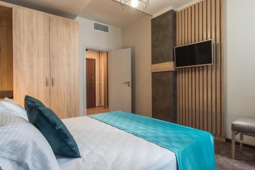 布尔加斯Green Luxury Apartments的一间卧室配有一张床和一台电视