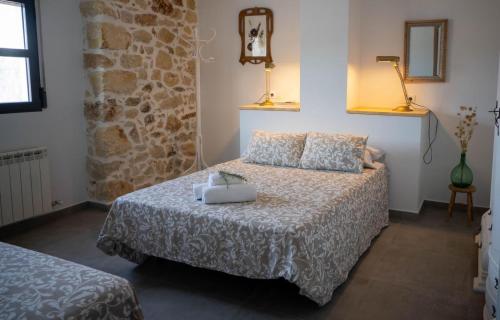 哈恩Alojamiento rural La Granja de Las Monjas的一间卧室设有一张床和石墙