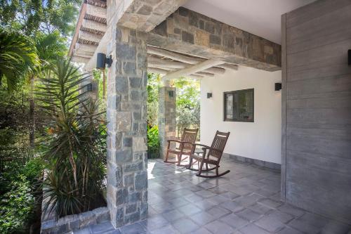 IguanaIguana Beach House的一个带两把椅子和石墙的庭院