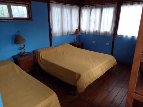 萨尔塔Cabañas La Caballeriza San Lorenzo的配有两张床铺的蓝色墙壁和窗户