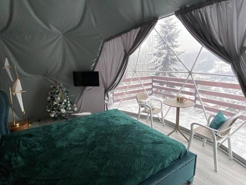 亚列姆切Karpatski Dzherela的一间卧室配有绿色的床和桌椅