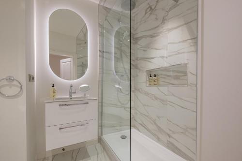 巴登-巴登查尔梅精品公寓的带淋浴、水槽和镜子的浴室