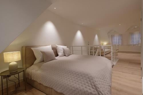 巴登-巴登查尔梅精品公寓的卧室配有白色的床和楼梯。