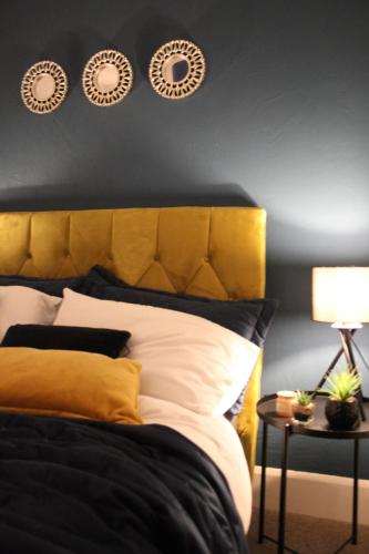 科尔切斯特The Velveteen Townhouse的一张带黄色床头板和墙上三个板的床