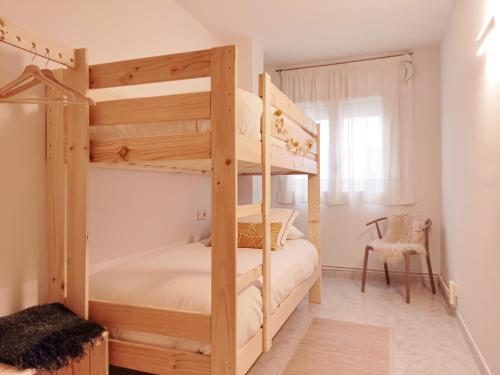 奥洛特Apartament Natura amb Calma的一间卧室配有两张双层床和椅子