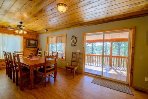 达克科里克村S`more Fun Cabin的一间带桌子和木制天花板的用餐室