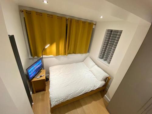 BelvedereDouble Bedroom with en-suite shower & free parking的一间小卧室,配有一张床和电视