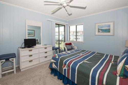 大西洋滩Seaspray II的一间卧室配有一张床和一个带电视的梳妆台