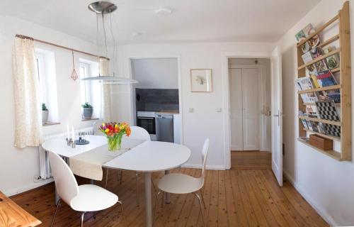 哈里斯莱Feddersen's Ferienwohnung的白色的用餐室配有白色的桌椅