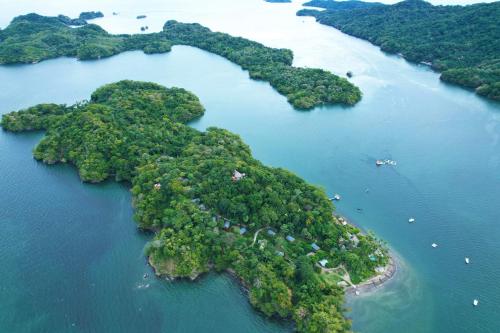 蓬塔雷纳斯Isla Chiquita Glamping Hotel的水体中的岛屿,其中有船只