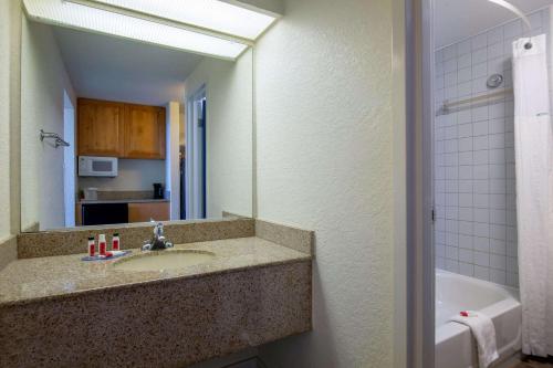 斩魔山纳格斯赫德海滩旅程住宿酒店的浴室配有盥洗盆、镜子和浴缸
