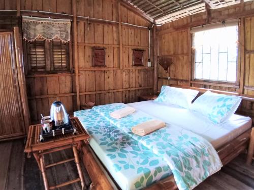 芹苴Mekong Delta Ricefield Lodge的一间卧室配有一张床,床头柜配有桌子