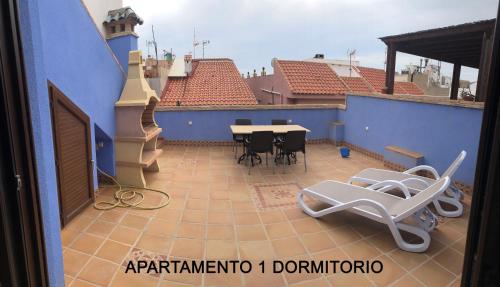 帕洛斯角MARIAGUERRERO - La Casita Azul的蓝色建筑中带桌椅的阳台