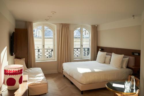 巴黎Hôtel du Sentier的一间卧室设有一张大床和两个窗户。