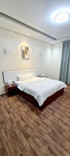 迪拜HAVANA HOLIDAY HOMES MIRDIF的一间卧室设有一张大床,铺有木地板