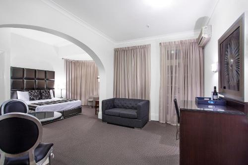 梅特兰梅特兰蒙皮奥美居酒店的酒店客房配有床、沙发和椅子