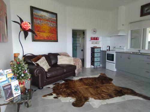 泰帕Taipa Coastal Retreat的客厅配有真皮沙发和毛皮地毯