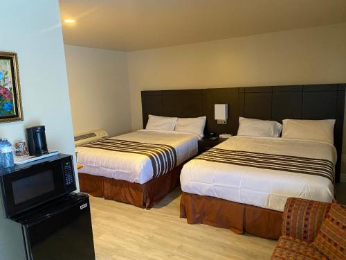哈里伯顿Silver Maple Motel的酒店客房设有两张床和电视。