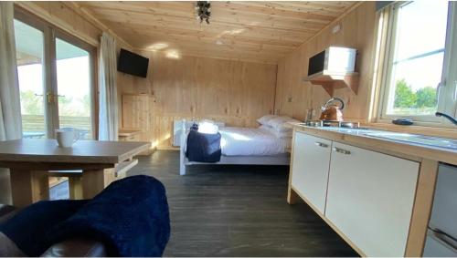 TuxfordBeautiful Wooden tiny house, Glamping cabin with hot tub 3的一间卧室配有一张床,厨房配有水槽