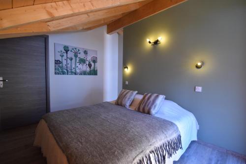 沃雅尼VAUJANYLOCATIONS - Marguerite的一间卧室设有一张床和木制天花板