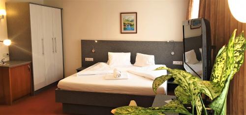 法克湖Gasthaus - Pension Kärntnerhof的酒店客房,配有床和植物
