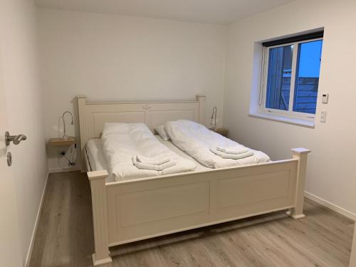 克拉克斯维克Spacious Apartment on N.P.Gøta 8a, Klaksvik的窗户客房内的一张白色床