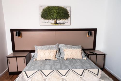 圣佩德罗·德·阿塔卡马Hostal Tulvak Atacama的一间卧室,卧室上方有一棵树,配有一张床