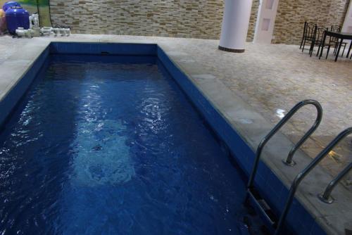 利雅德Al Rafahya Crown的一个带桌椅的蓝色海水游泳池
