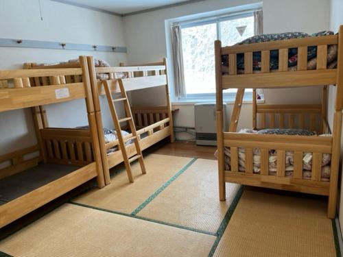 草津草津高原青年旅舍的客房设有三张双层床和一扇窗户。