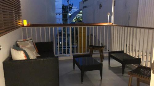 华欣Yellow door Hua Hin的阳台配有沙发、椅子和栏杆
