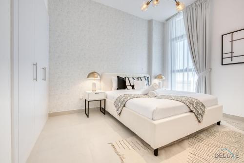 迪拜Alluring 1BR at The Pulse Blvd C3 Dubai South by Deluxe Holiday Homes的白色的卧室设有床和窗户