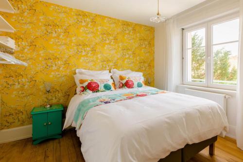 科尔马Maison 1934 - Colmar Gare & Parking gratuit的一间卧室设有一张床和黄色的墙壁